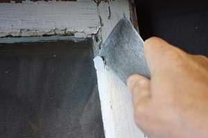 photo removing old loose glazing putty from a window sash
