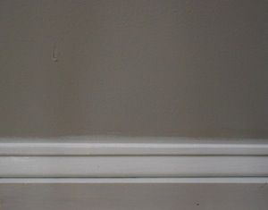 photo latex acrylic caulk between a wall and baseboard molding