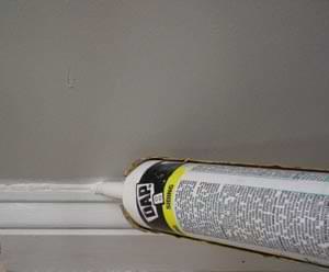 photo demonstrating how to caulk a crack between a baseboard and a wall