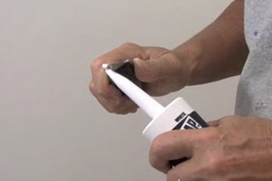 photo demonstrating how to cut the tip off a caulk tube