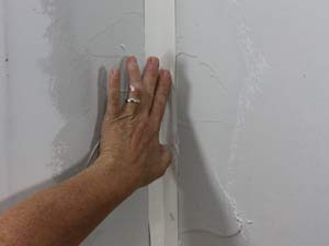 photo placing paper tape into an inside drywall corner