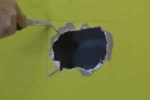 photo cutting with a saw to square a wall hole