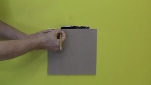 photo marking a piece of drywall to patch a wall hole