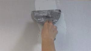 photo applying a first coat of joint compound over a drywall butt joint