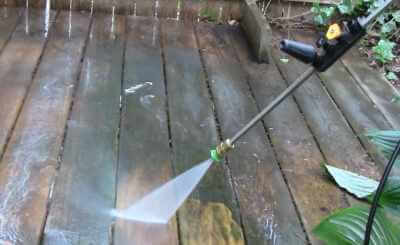 photo using a pressure washer to clean a deck