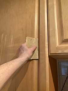photo hand sanding kitchen cabinets