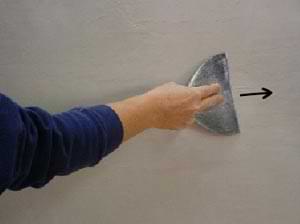 photo shaving ridges off the surface of white coat plaster