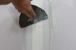 photo stroking out the end of a drywall seam