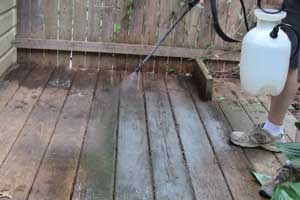 photo spraying oxygen bleach onto a deck