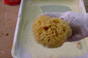 photo demonstrating how to squeeze a natural sponge to expose the crevices