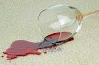 photo of a wine glass spilling wine on carpet